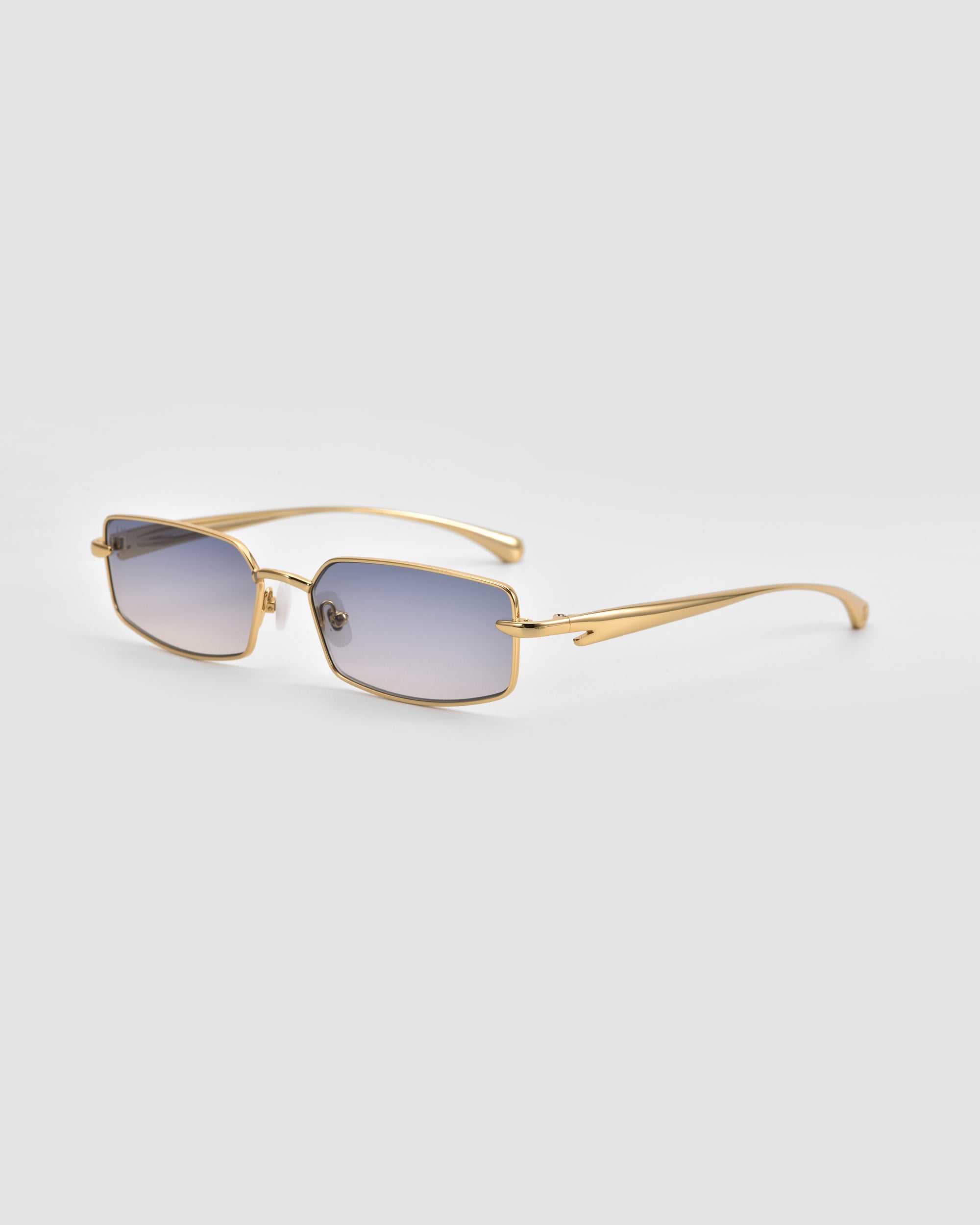 The For Art's Sake® Lucio sunglasses feature a gold frame, rectangular shape, light blue gradient lenses, and sleek 3D swoosh temples, showcased on a plain light gray background.