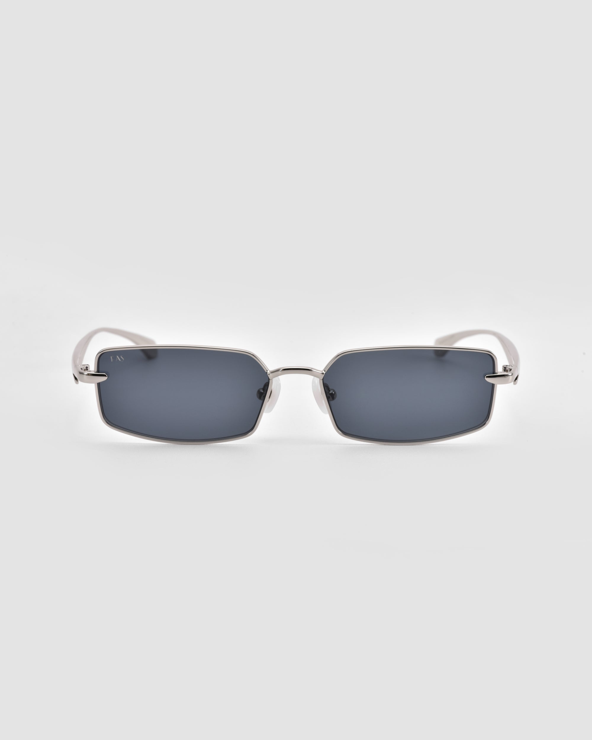 For Art's Sake® Lucio sunglasses feature rectangular sculpted dark-tinted lenses and slim metallic silver frames, shown against a plain light gray background.