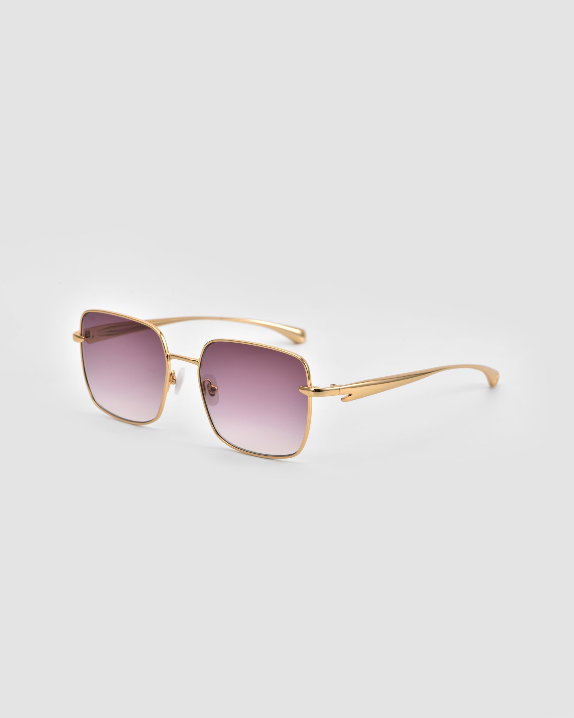 The For Art’s Sake® Edge sunglasses feature gold frames, a rectangular shape, and square purple gradient lenses with sculptural details, shown against a plain light gray background.