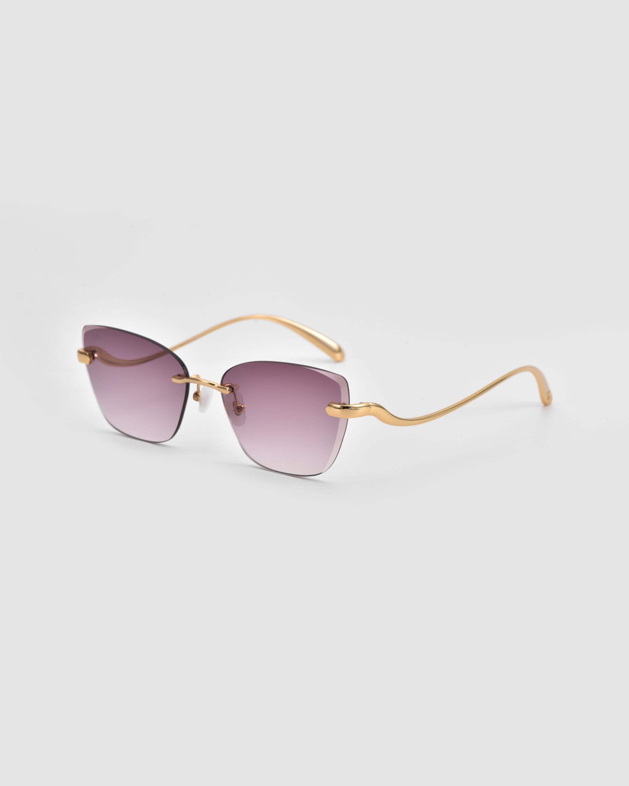 The For Art's Sake® Spark sunglasses feature a sculptural, rimless design with square gradient purple lenses and gold wavy arms, shown on a light grey background.