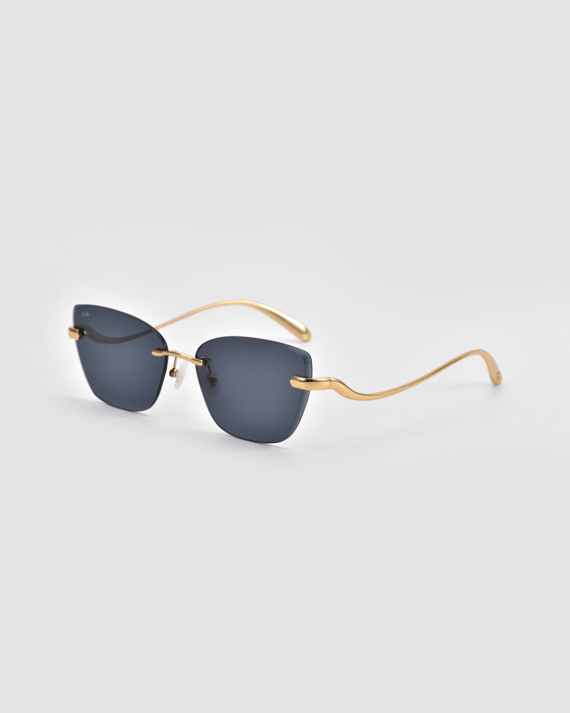 For Art's Sake® Spark features rimless cat-eye sunglasses with dark rectangular lenses and slim, curved gold metal arms, showcased on a light gray background for a bold, modern look.