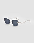 The For Art's Sake® Spark sunglasses feature rimless, dark square lenses and thin silver metal arms with a subtle 3D sculptural curve, showcased on a light gray background.