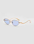 For Art's Sake® Rebirth sunglasses feature gold frames, oval light blue lenses, and wavy thin arms for a futuristic look, showcased on a plain light gray background.
