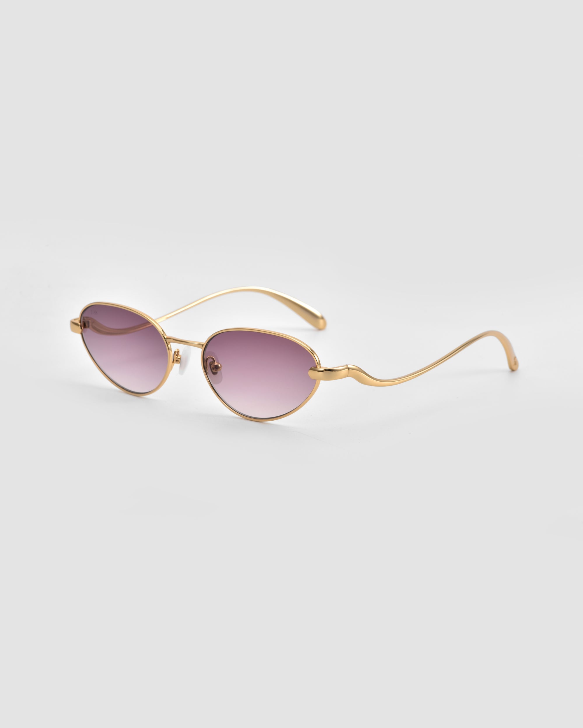 For Art's Sake® Rebirth sunglasses feature gold oval frames, purple-tinted lenses, and subtly wavy arms, merging classic elegance with a modern twist. Presented on a light gray background, they capture the spirit of innovative style.