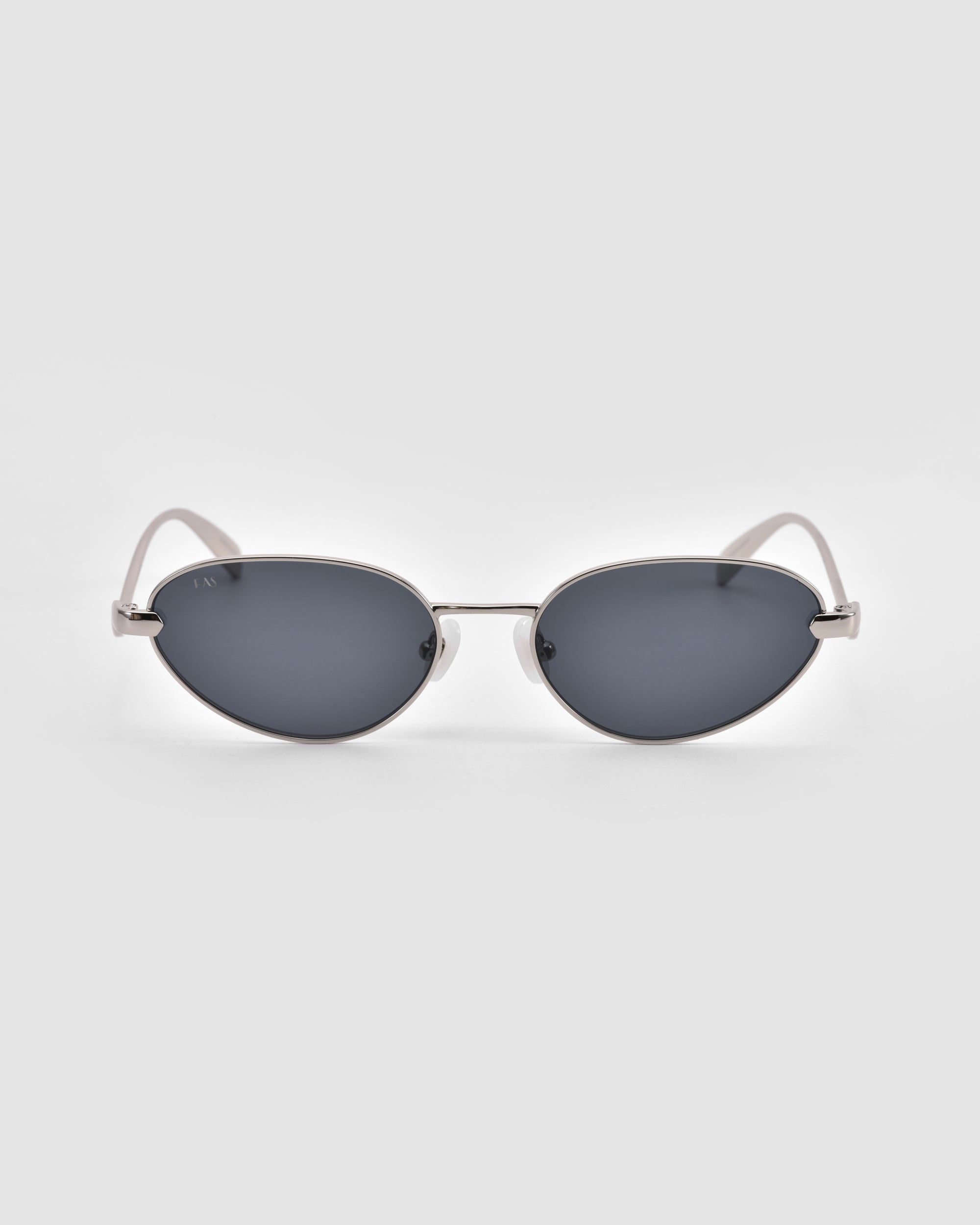 The Rebirth sunglasses by For Art's Sake® feature an oval shape, dark lenses, and a thin silver sculptural 3D metal frame, displayed facing forward on a plain light gray background.