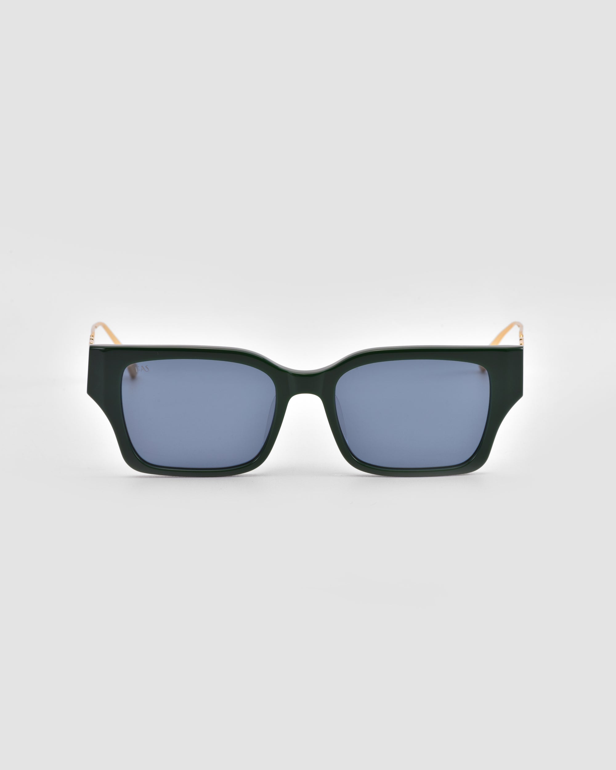 The For Art's Sake® Incomplete sunglasses feature boxy dark green frames, blue-tinted lenses, and mosaic metal details, shown against a light grey background.