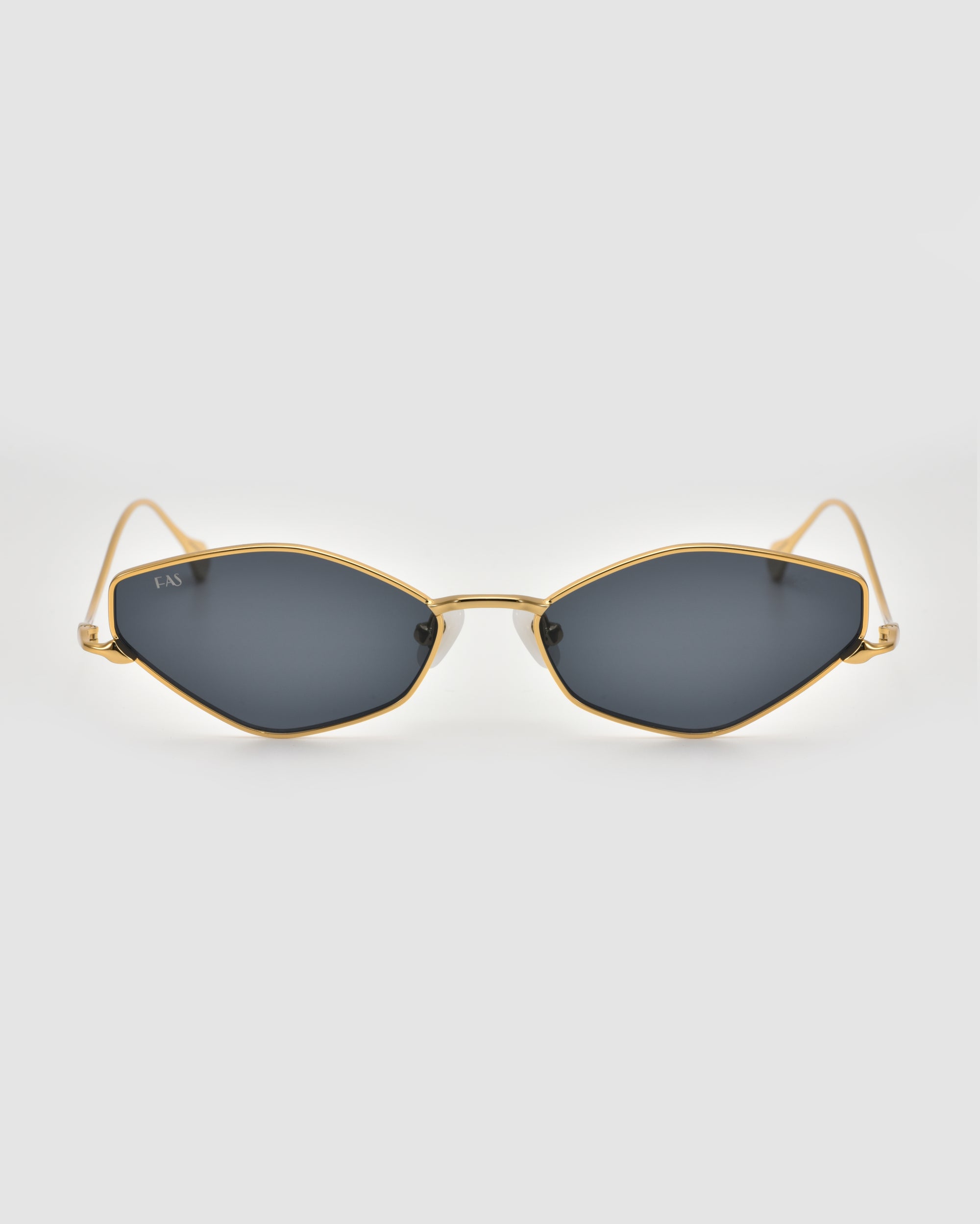 The Moment sunglasses by For Art's Sake® feature gold frames with a geometric cat-eye design and dark lenses, shown facing forward on a plain light gray background.