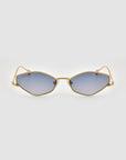 The Moment sunglasses by For Art's Sake® feature a geometric silhouette with gold metal frames and blue-tinted lenses, showcased on a plain light gray background.