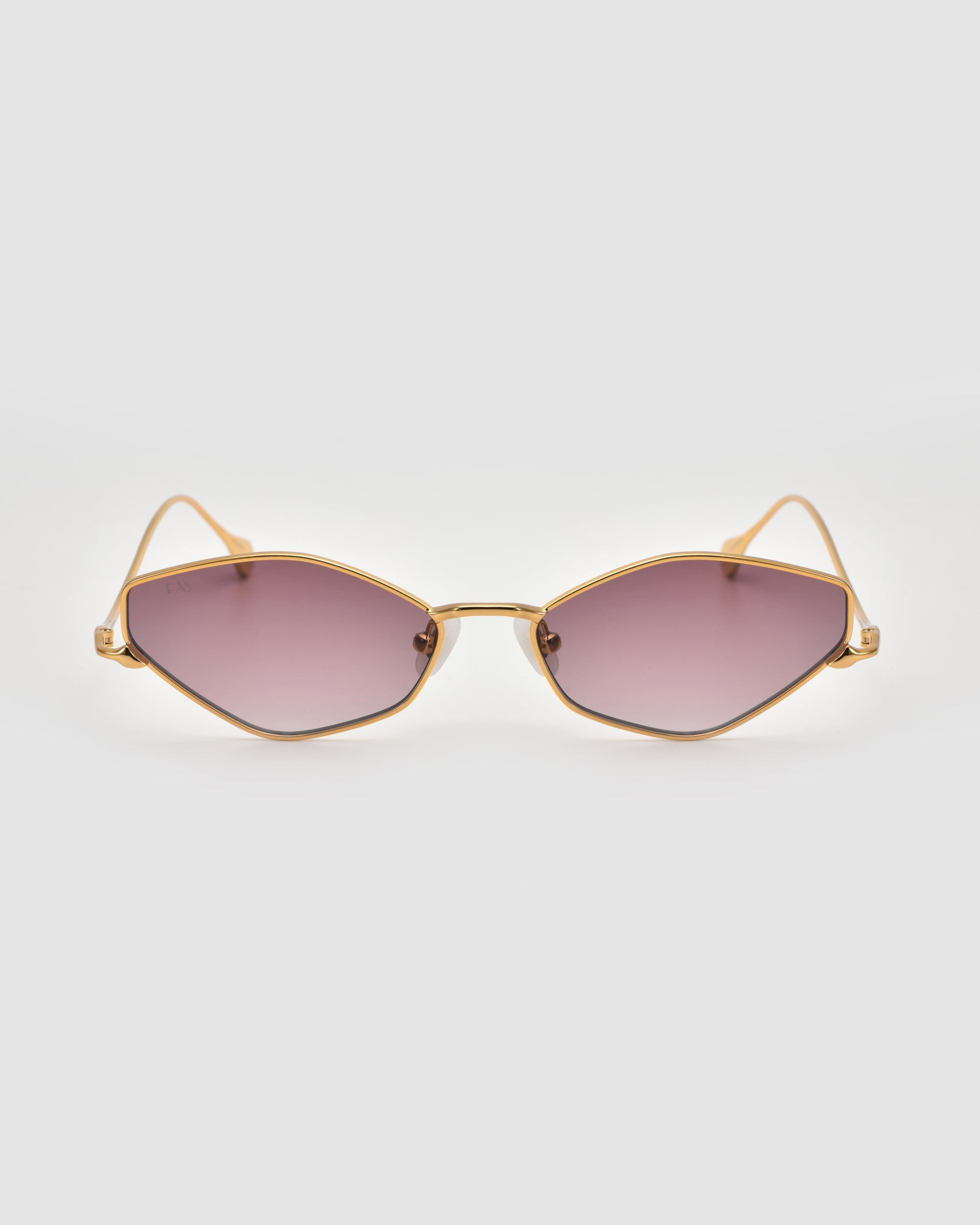 The For Art's Sake® Moment sunglasses feature a gold geometric metal frame and slightly hexagonal pink-tinted lenses, shown against a light gray background.