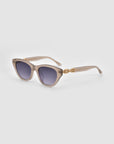 The Cuts by For Art's Sake® are beige square cat-eye sunglasses featuring dark gradient lenses and 3D weaved gold chain detailing on the temples, shown on a light grey background.
