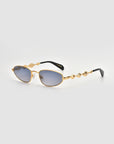 Droplets by For Art's Sake®: gold metal frame sunglasses with wavy sculpted arms and oval blue-tinted lenses, shown on a light gray background for a subtle retro vibe.