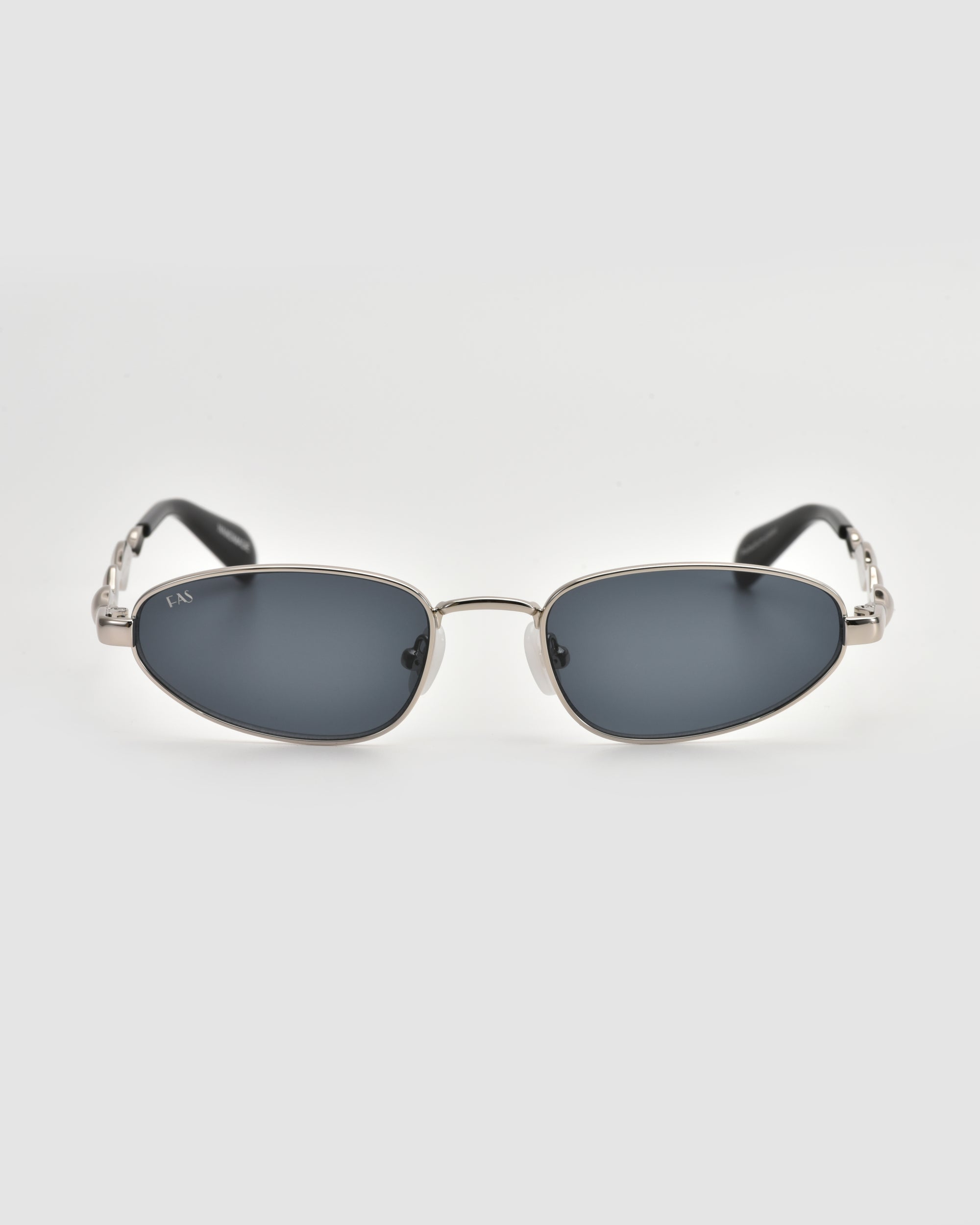 Droplets by For Art's Sake® are retro oval sunglasses with silver metal frames and dark lenses, shown facing forward on a plain white background.