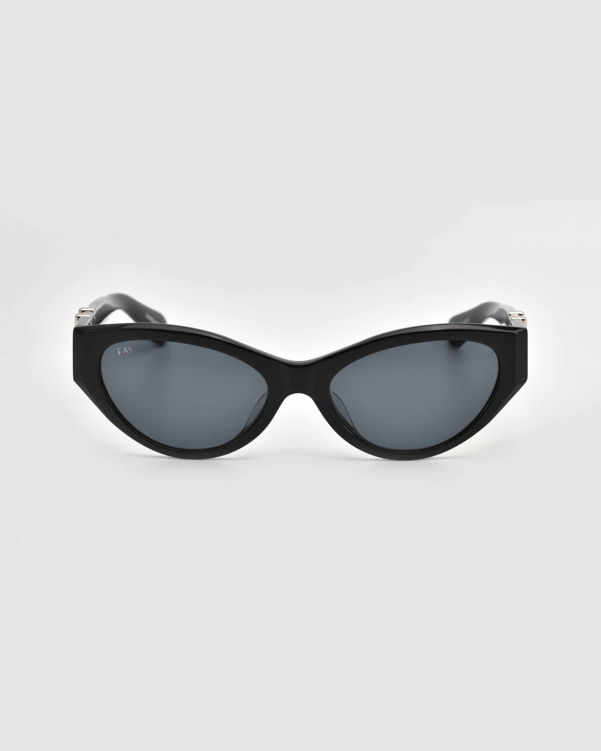 The For Art's Sake® Halo(S) black cat-eye sunglasses, featuring a sculptural acetate frame and dark lenses, are displayed facing forward on a plain light gray background.