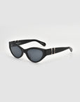 For Art's Sake® Halo(S) black cat-eye sunglasses feature dark lenses, a sculptural acetate frame, and gold accents on the temples, shown against a plain white background.