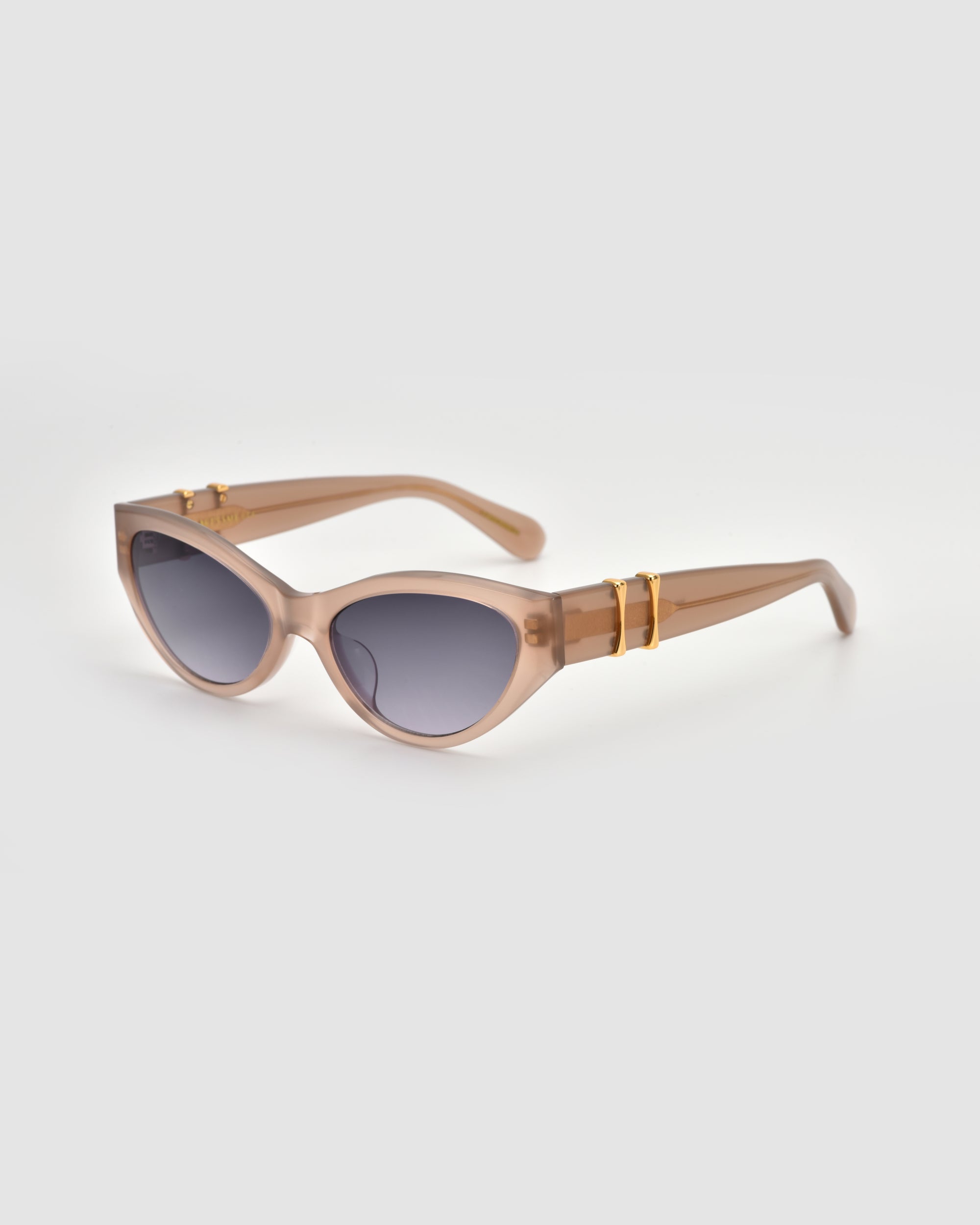 For Art's Sake® Halo(S) beige cat-eye sunglasses with a sculptural acetate frame, dark lenses, and gold accents on the arms, displayed on a plain light gray background.