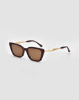 The Harmony(S) square minimal sunglasses by For Art's Sake® feature dark brown frames, gold arms, and brown tinted lenses, shown on a light gray background.