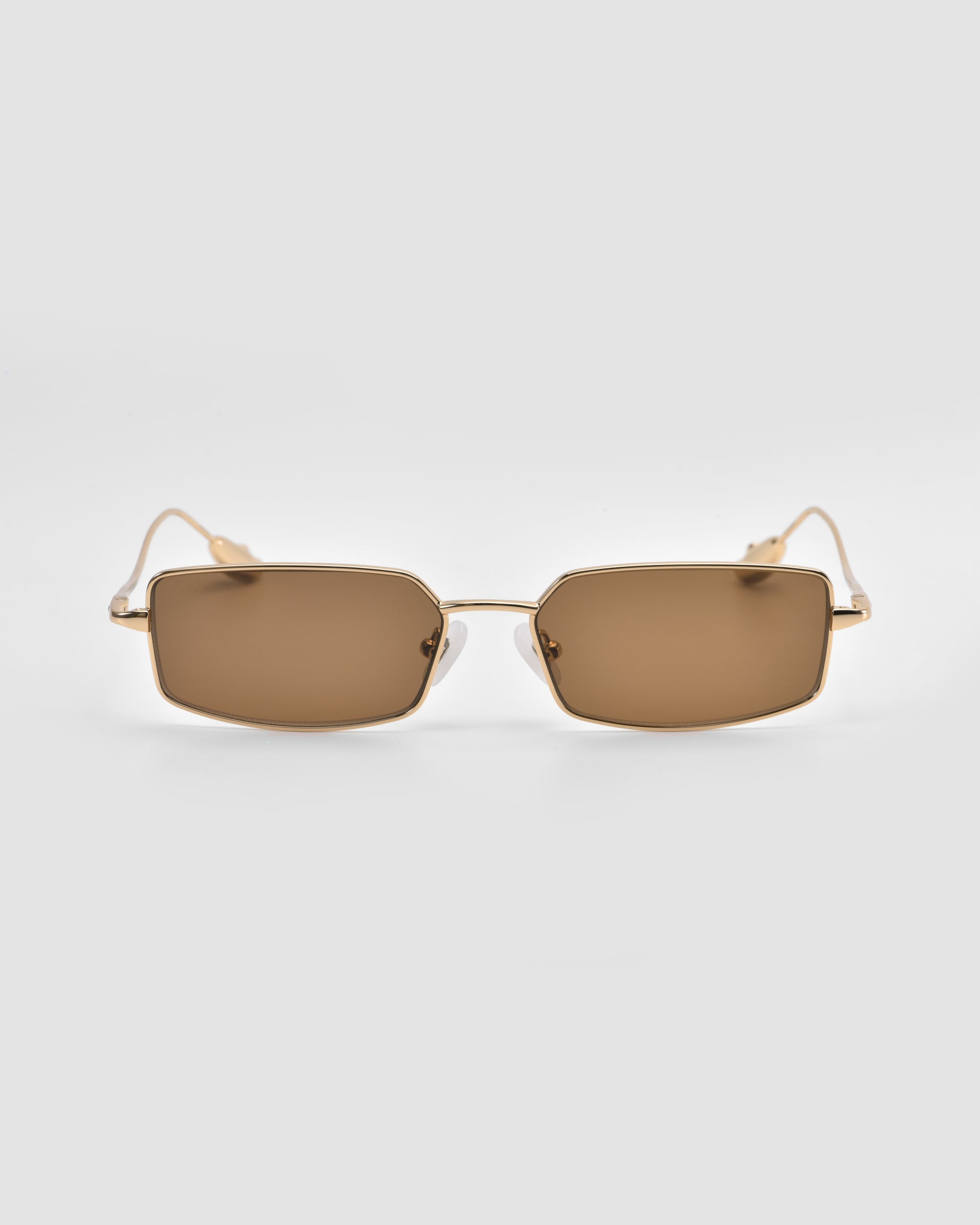 For Art's Sake® Calla II rectangular sunglasses feature gold metal frames and brown tinted lenses in a lightweight, sculptural design, shown facing forward on a plain light gray background.