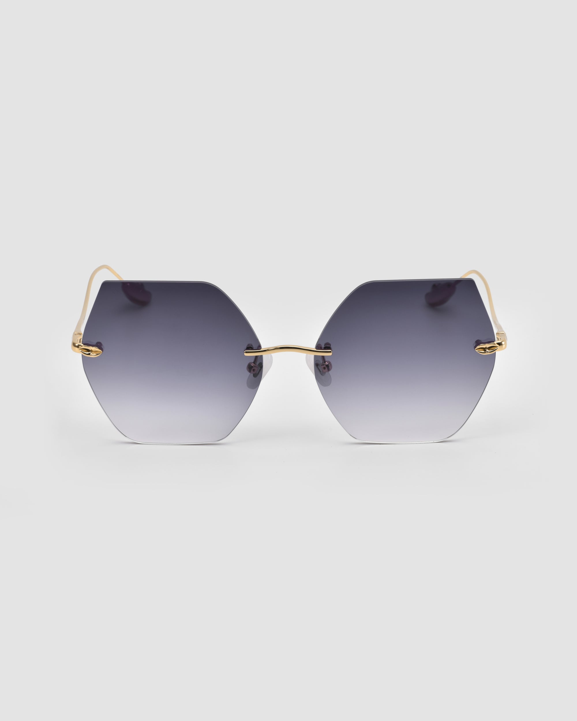 For Art's Sake® Georgia hexagonal oversized frameless sunglasses with sculpted metal temples and gradient dark gray lenses, shown against a plain light gray background.