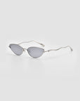Lake cat-eye sunglasses by For Art’s Sake®, featuring a silver frame, reflective lenses, and sculpted wavy arms, displayed on a light grey background.