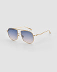 For Art's Sake® Lines: Gold-framed oversized aviator sunglasses with blue gradient lenses and sculpted wavy temples, highlighting the brand’s signature style on a white background.