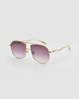 Lines by For Art's Sake®: Gold-framed oversized aviator sunglasses with purple gradient lenses and sculpted temples, shown on a plain light gray background.