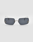 Magnolia by For Art's Sake®: sculptural, frameless sunglasses featuring rectangular dark grey lenses, a slim metal bridge, and minimalist metal arms are showcased against a plain white background.