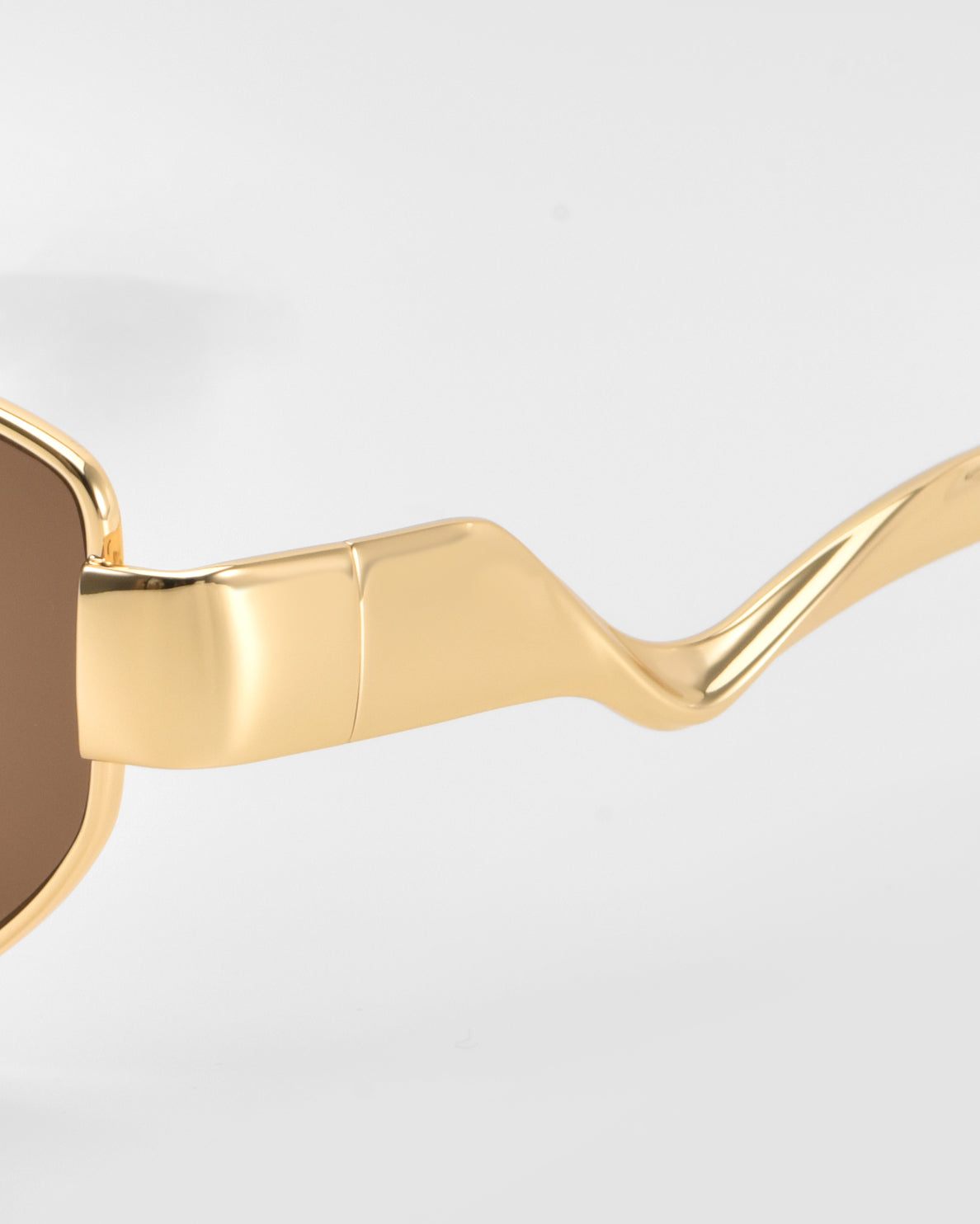 Close-up of Abstraction II sunglasses by For Art's Sake®, featuring a geometric metal frame, wavy arms, and brown lenses against a plain white background.