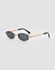 The Mesa I sunglasses by For Art's Sake® feature gold metal frames, black oval lenses, and black-tipped arms, displayed on a light gray background.