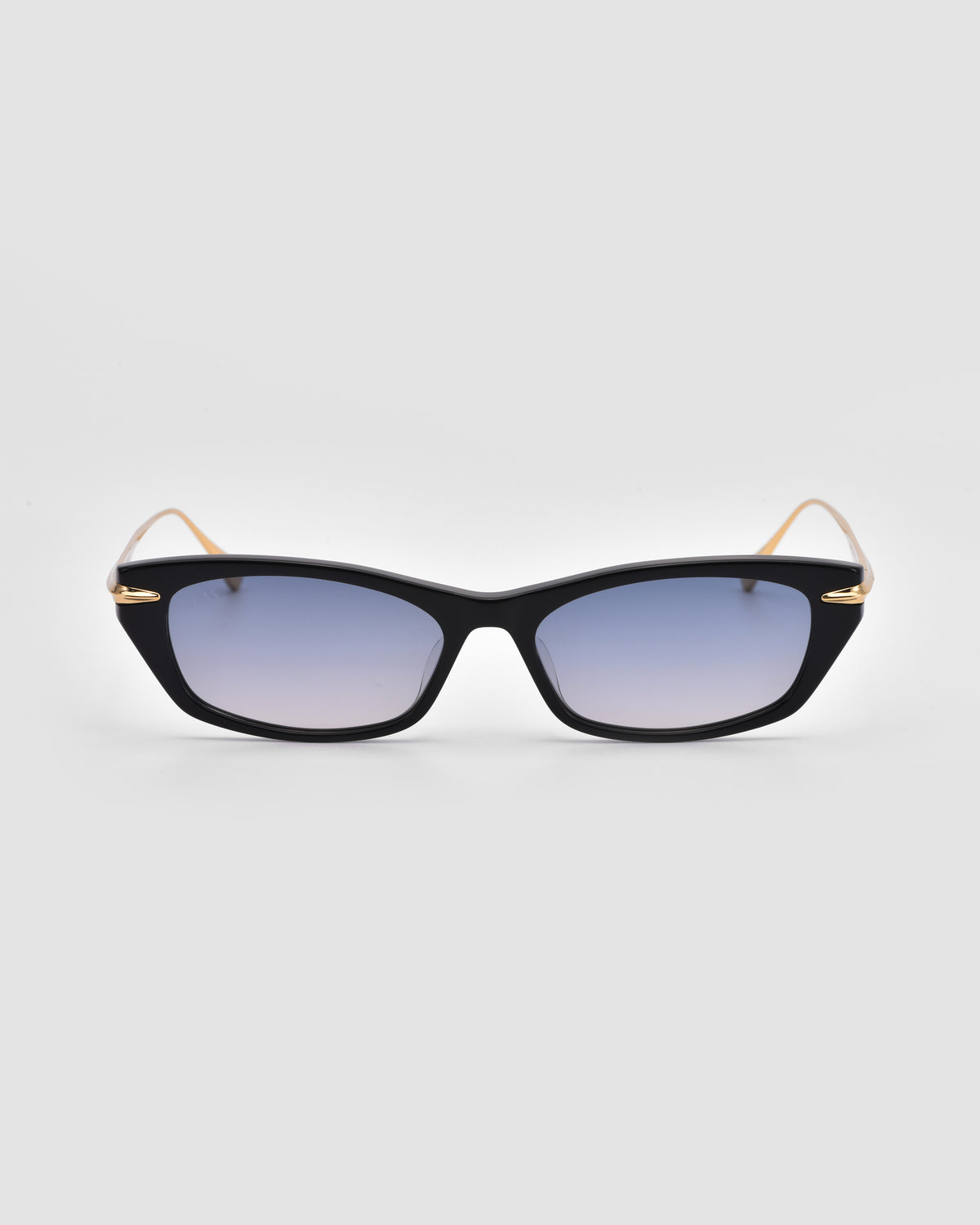 For Art’s Sake® Marisol I: Black cat-eye sunglasses with blue gradient lenses, thin gold temples, and an acetate frame, shown on a light gray background for chic sun protection.
