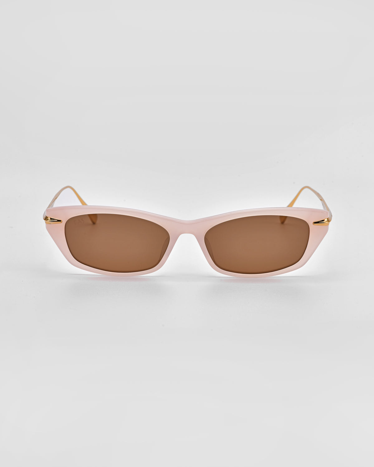 Marisol I by For Art’s Sake® are rectangular feminine sunglasses featuring light pink frames, brown-tinted lenses, and thin gold arms, shown on a plain white background.
