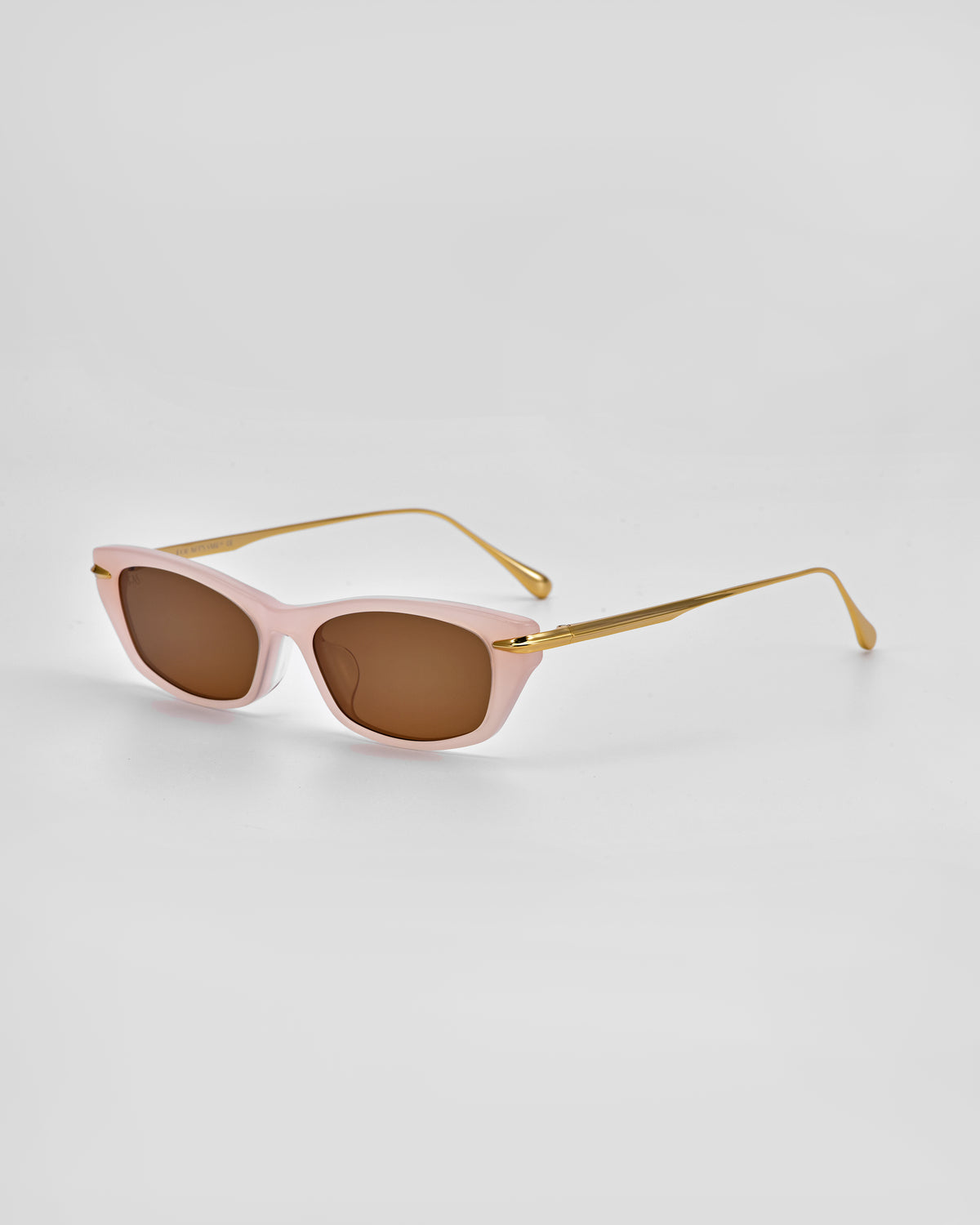 The For Art’s Sake® Marisol I features pale pink frames, brown lenses, and gold metal arms—versatile sunglasses displayed on a white background for stylish everyday sun protection.