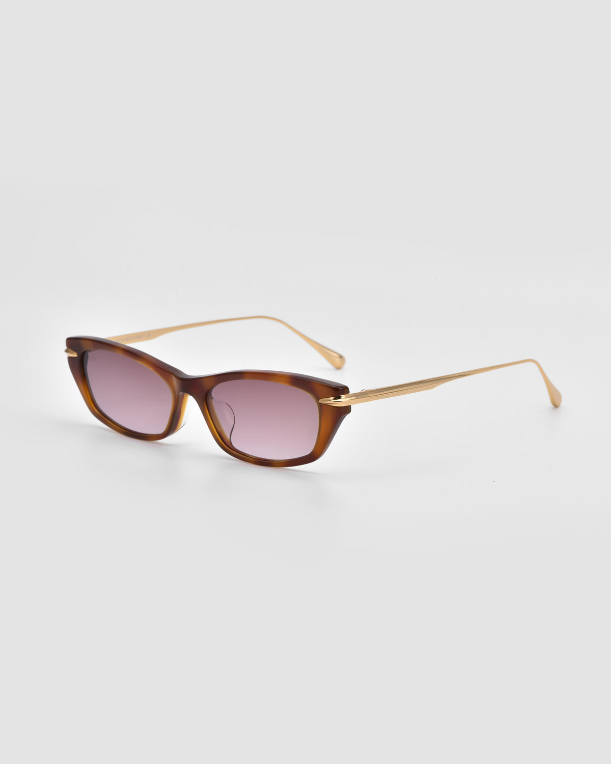 The Marisol I by For Art’s Sake® features a brown acetate frame, light purple lenses, and slim golden arms—stylishly displayed against a light grey background.