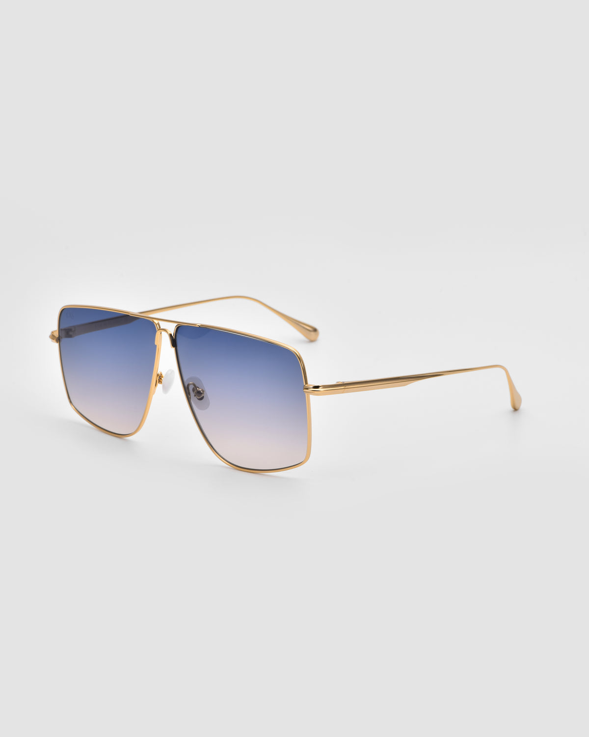 Marisol II by For Art’s Sake®: Gold-framed oversized aviator sunglasses with square blue-gradient lenses, thin temples, and sculpted metal detailing on a light gray background for a modern, stylish look.