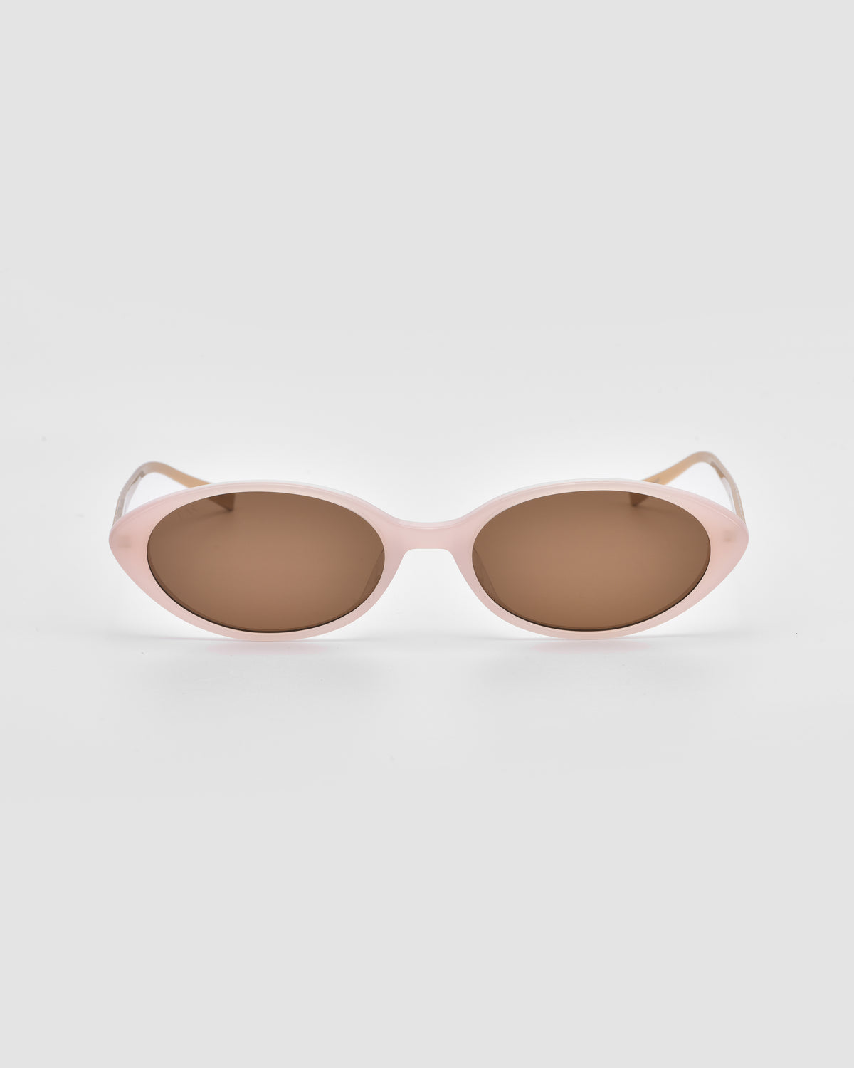 Solana II by For Art’s Sake®—light pink oval acetate sunglasses with brown tinted lenses, styled on a white background for a chic, modern look.