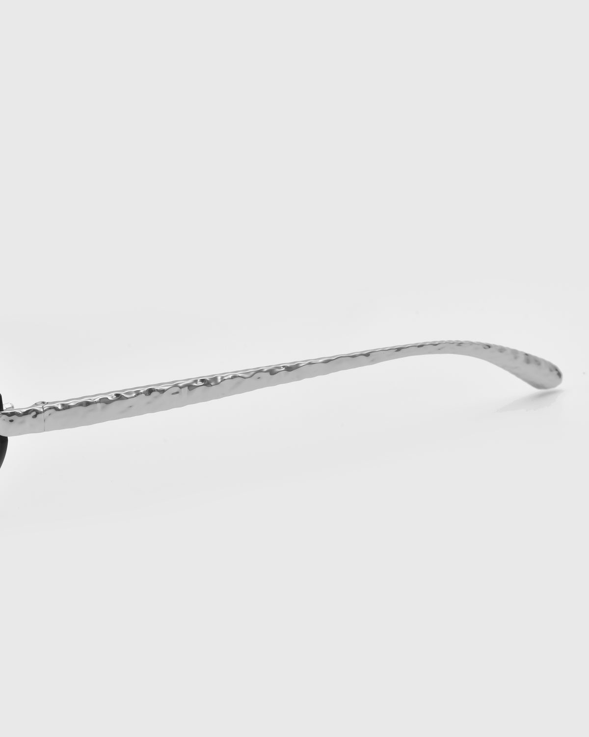 A close-up of the Shimmer II by For Art’s Sake® shows its silver, textured eyeglass arm with jewellery-inspired temples against a plain white background.