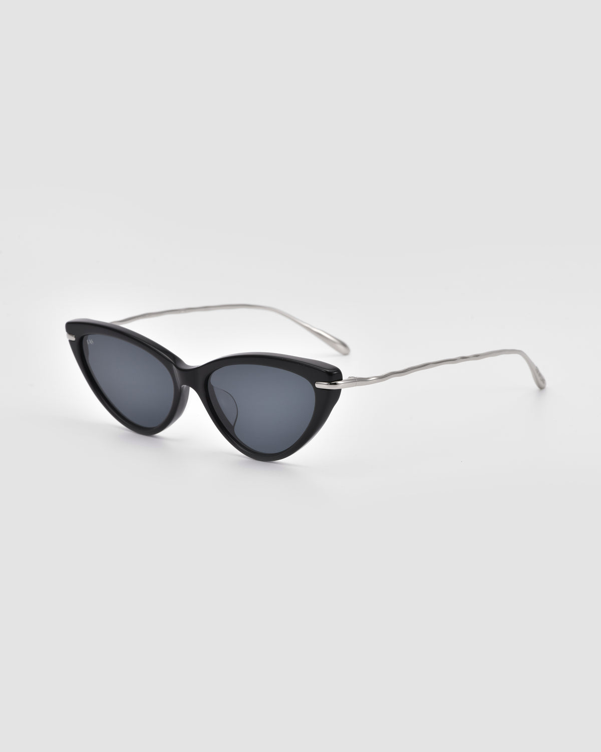 For Art’s Sake® Aurora: Black cat-eye sunglasses with dark lenses and jewellery-inspired sculpted metal temples, shown on a plain light gray background.