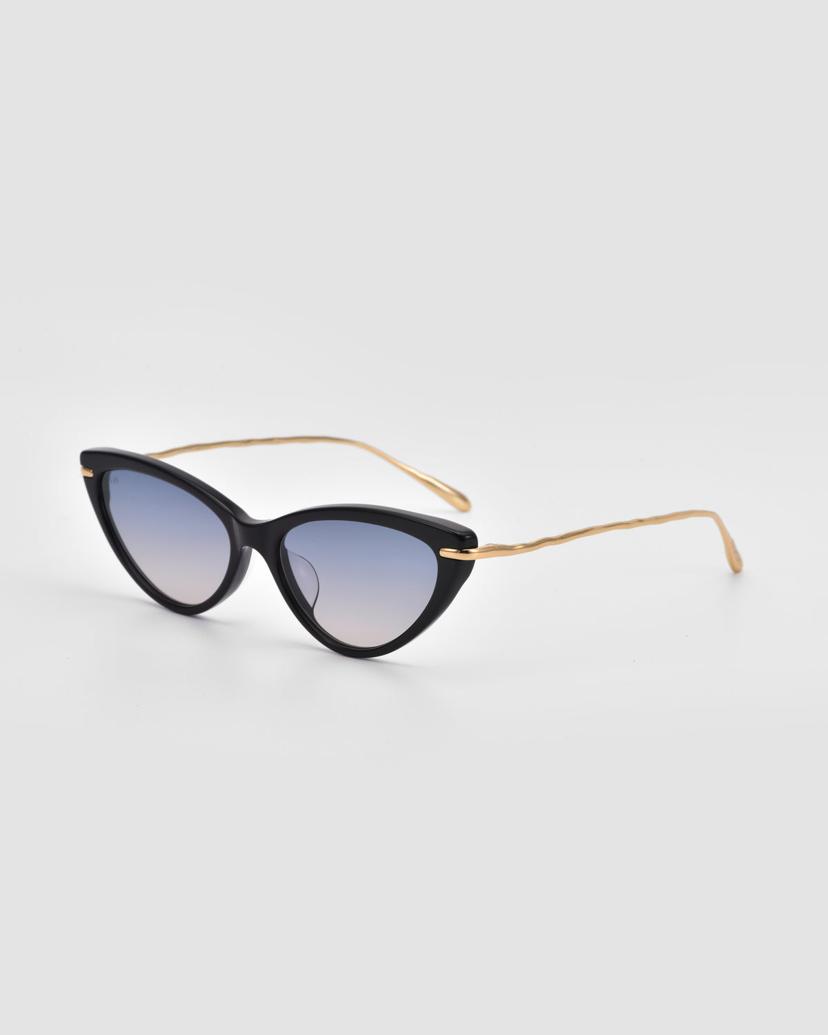 Aurora by For Art’s Sake®: Black cat-eye sunglasses with jewellery-inspired sculpted metal temples and gradient lenses, set against a plain light gray background.