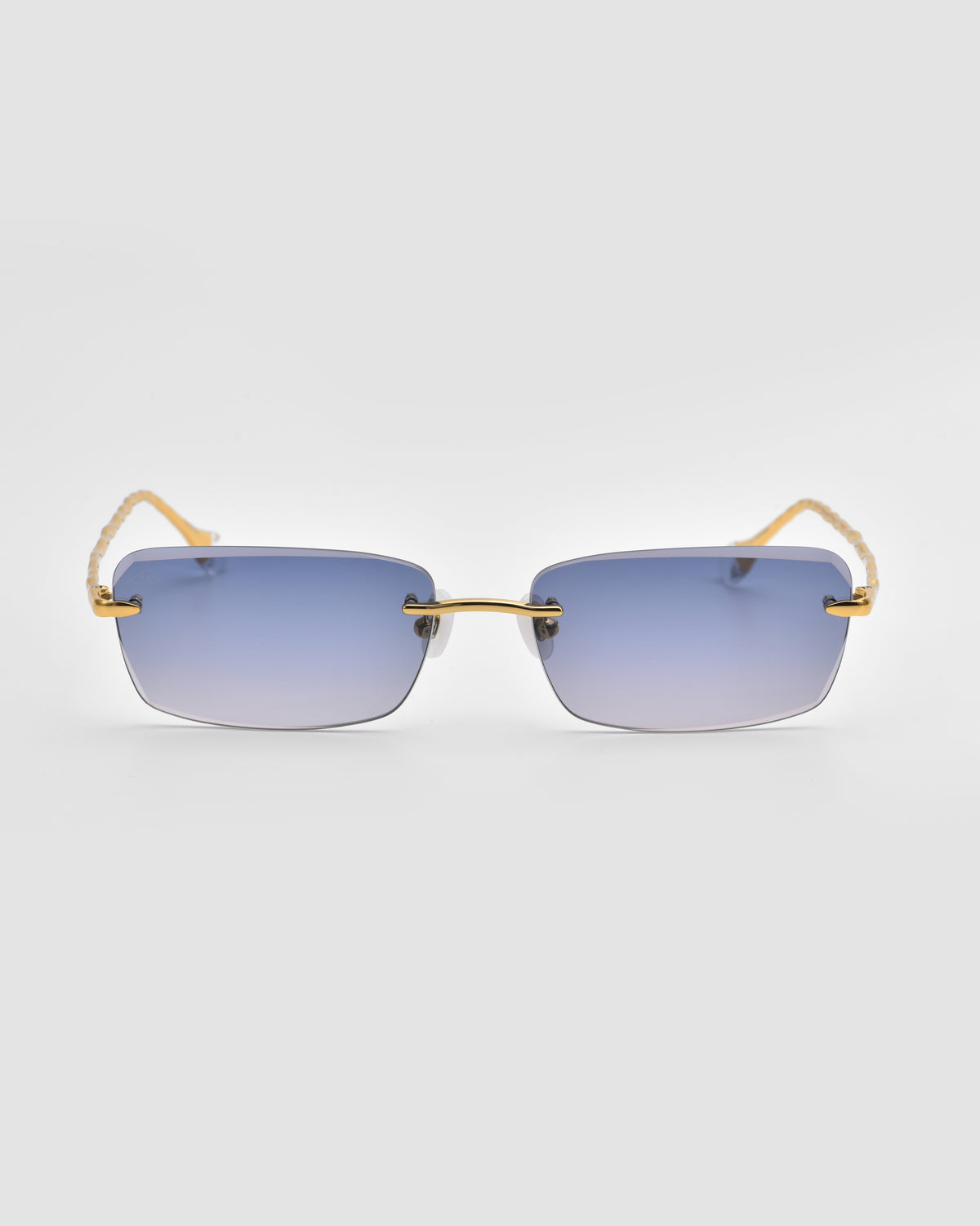 Sol I sunglasses from For Art’s Sake® feature gradient blue lenses, gold temples with sculpted nylon tips, and a slim gold bridge, shown against a plain light gray background.