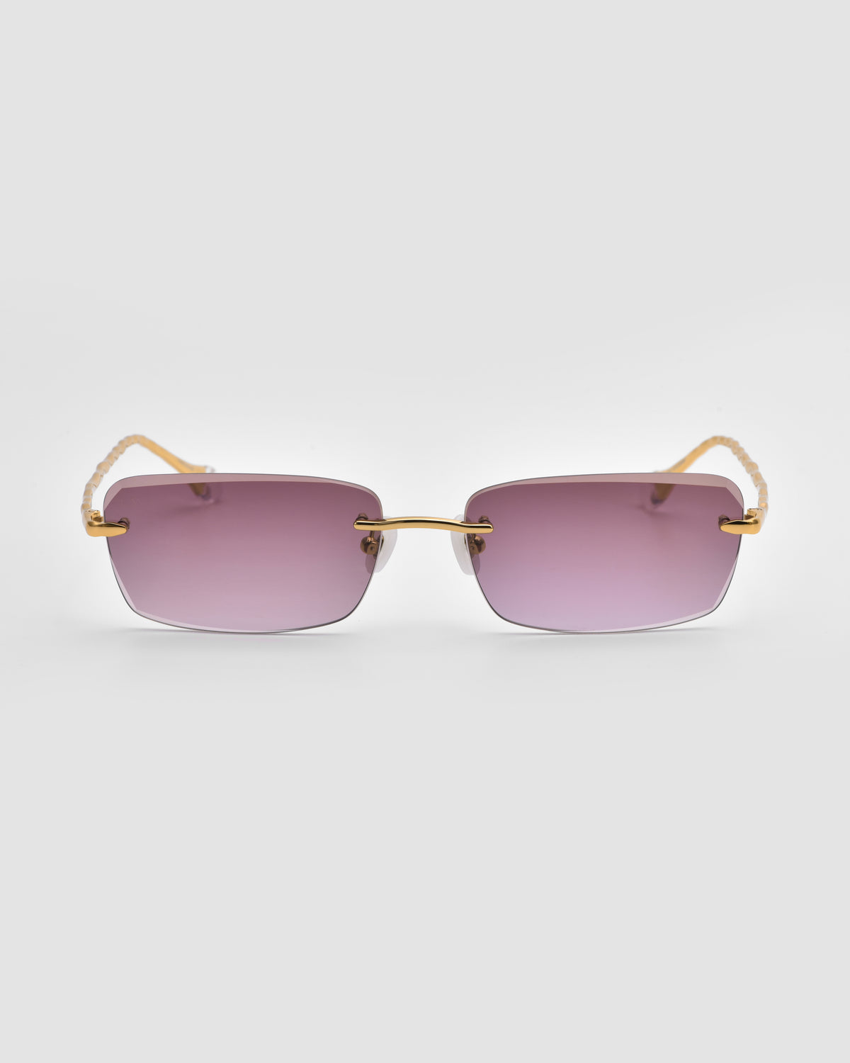 Sol I sunglasses from For Art’s Sake®, featuring gold frames, purple-tinted lenses, and sculpted nylon temple tips, photographed on a plain white background.