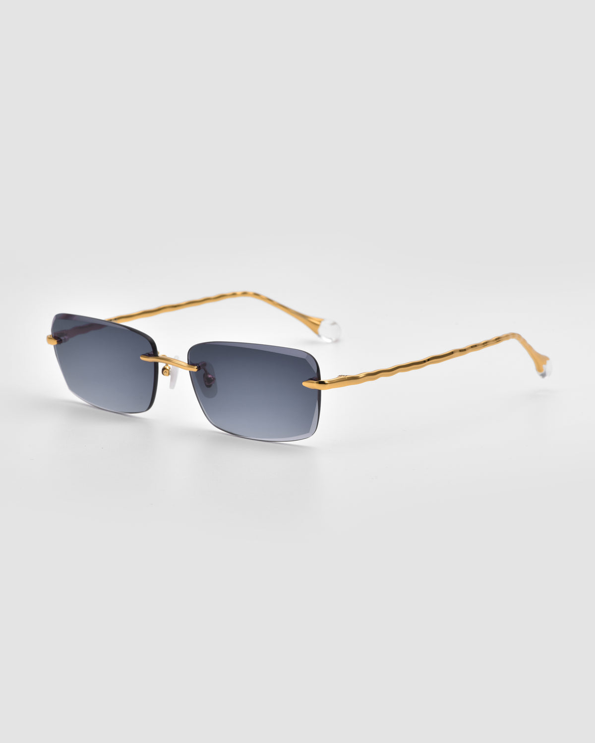 For Art’s Sake® Sol I: Gold-rimmed rectangular sunglasses with dark lenses and thin wavy arms with sculpted nylon temple tips, shown on a light gray background.