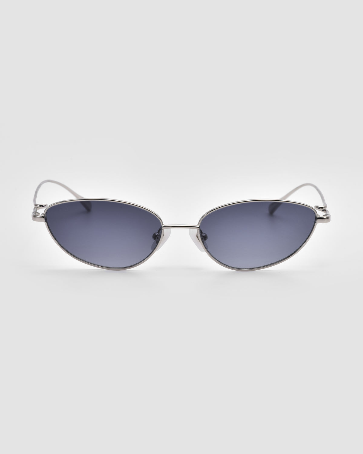 Ozanne I by For Art’s Sake®: Silver-framed cat-eye sunglasses with dark tinted lenses, displayed on a light gray background.