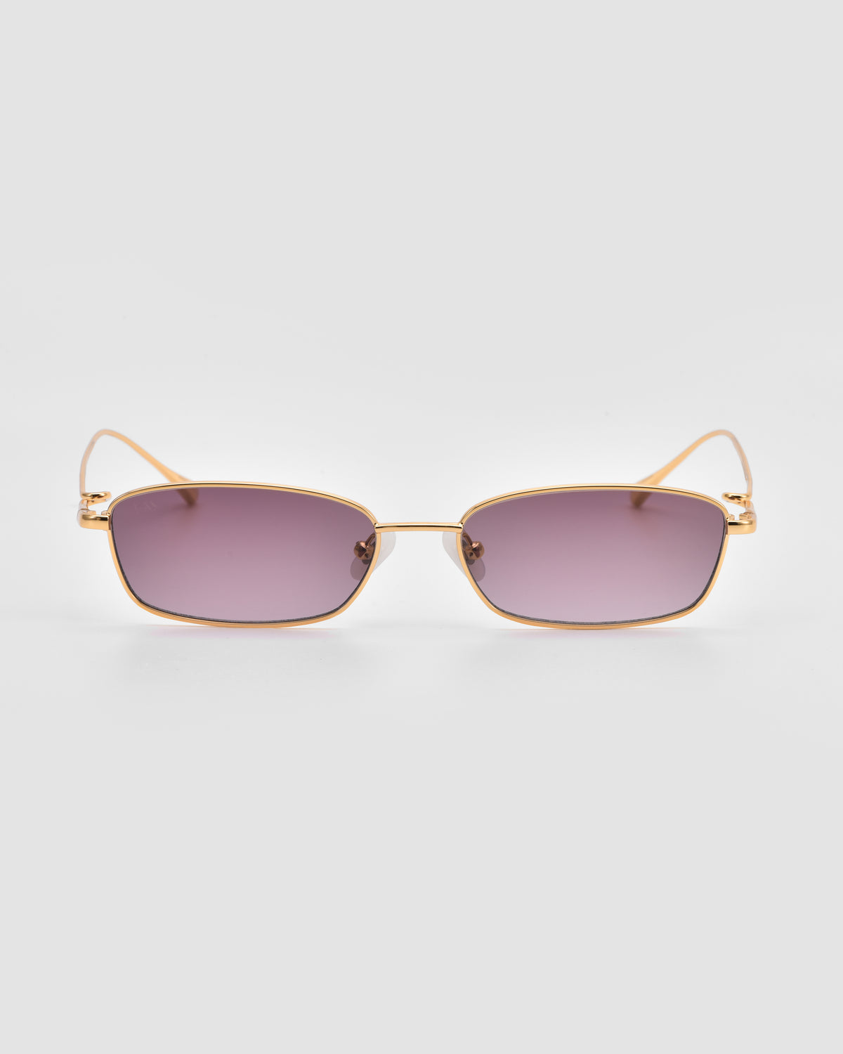 Ozanne II by For Art’s Sake®: Gold-framed rectangular sunglasses with purple-tinted lenses and sculptural looped temples, shown on a plain light gray background.
