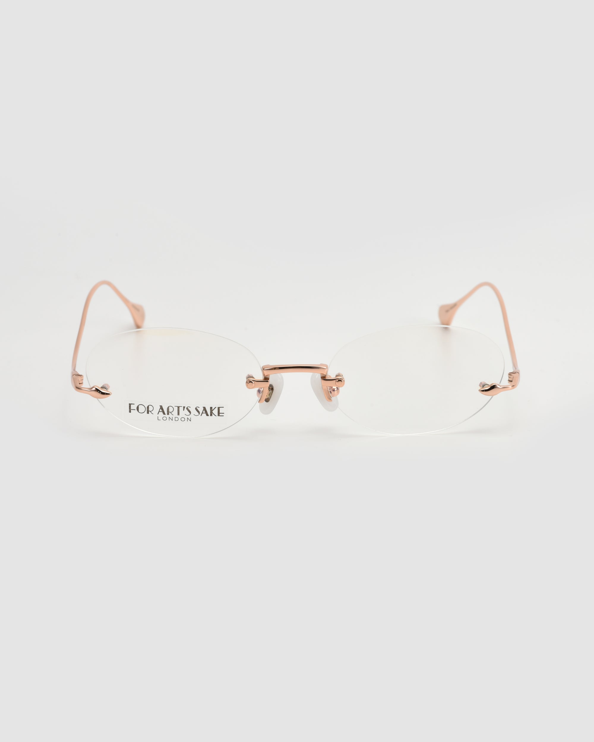 A pair of lightweight, rimless Waver eyeglass frames by For Art's Sake®, featuring rose gold metal arms and bridge, displayed on a white background. The left lens shows the "For Art's Sake" branding in small text.