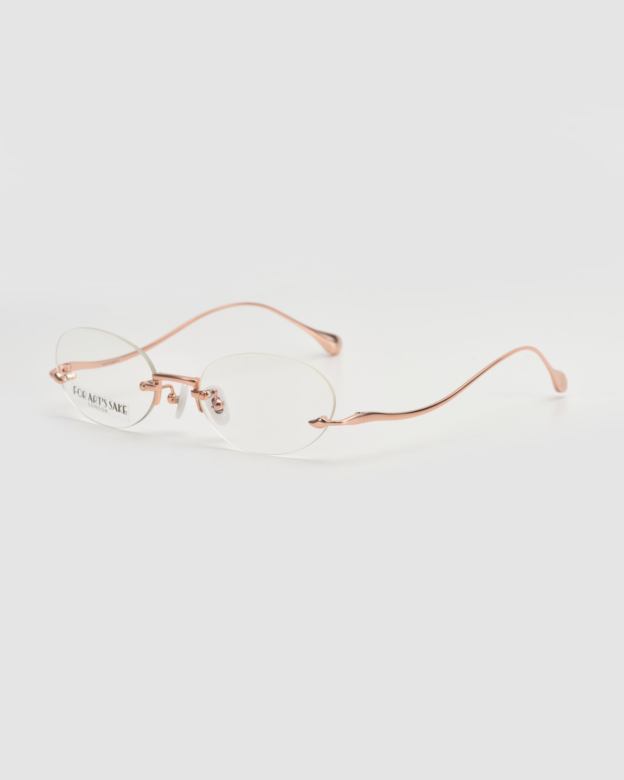 The For Art's Sake® Waver features lightweight, rimless eyeglass frames with round clear lenses and rose gold metal temples, shown on a plain white background.