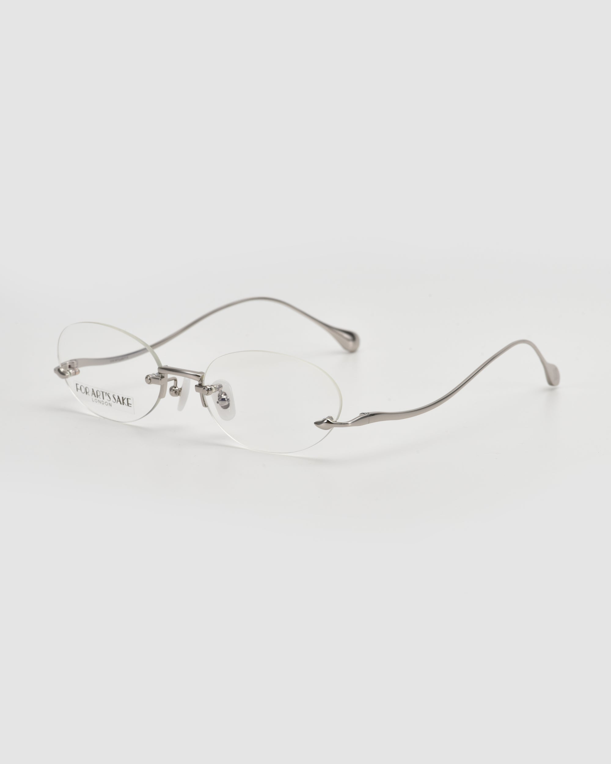 The For Art's Sake® Waver features oval rimless eyeglasses with thin silver metal arms and clear lenses on a white background—ideal for minimalism lovers.