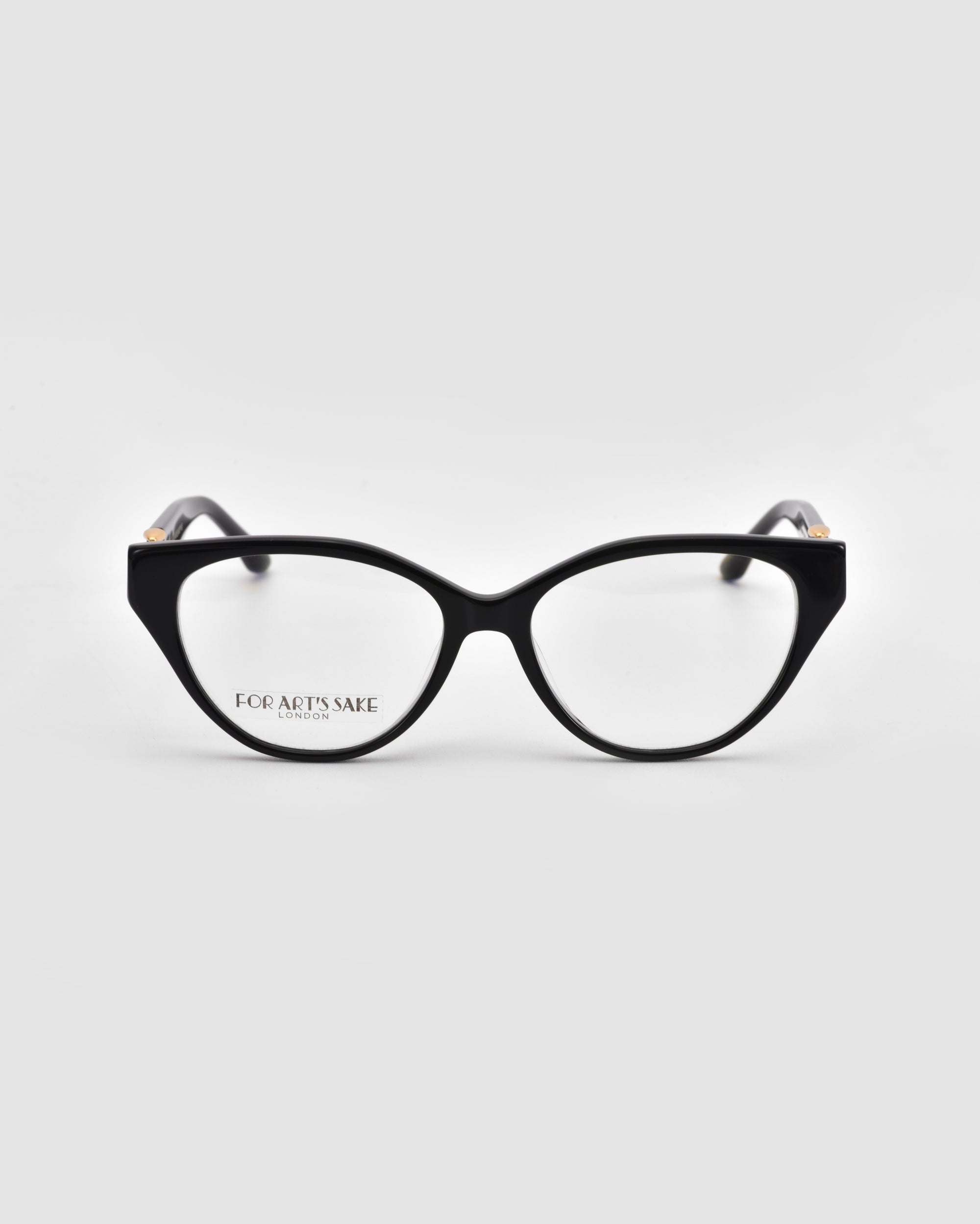 The Act by For Art's Sake®: black cat-eye eyeglasses with clear lenses and a lightweight frame, shown front-facing on a light gray background. The left lens displays small "FOR ART'S SAKE LONDON" text.