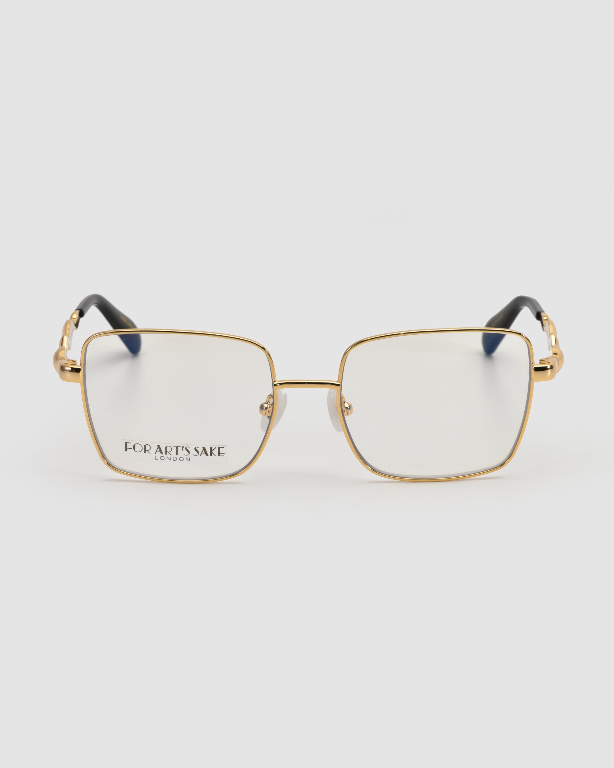 Fluid by For Art's Sake®: Gold metal eyeglass frames with a soft-square shape, clear lenses, and black temple tips, shown on a white background. "FOR ART’S SAKE LONDON" is printed in black on the left lens.