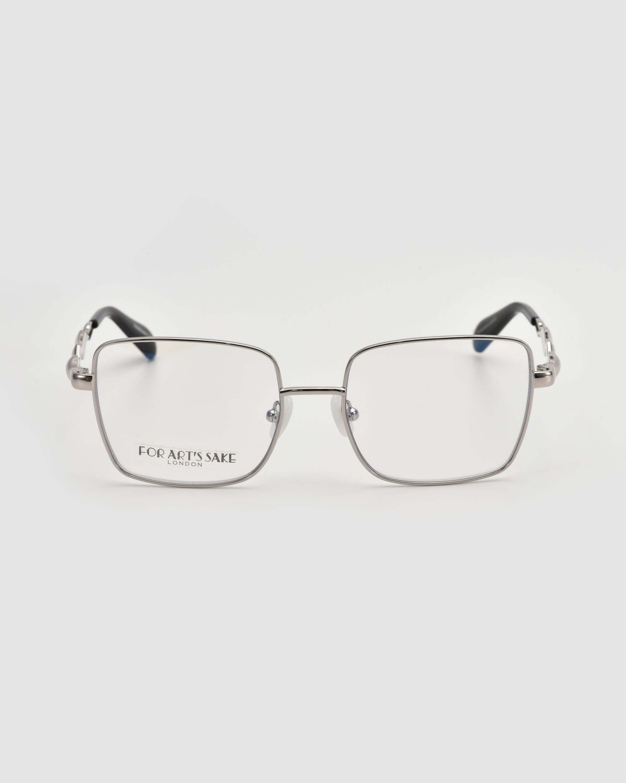 The Fluid by For Art's Sake® is a pair of soft-square silver metal eyeglass frames with clear lenses and black temple tips. Displayed on a white background, the left lens showcases the "For Art's Sake" branding.