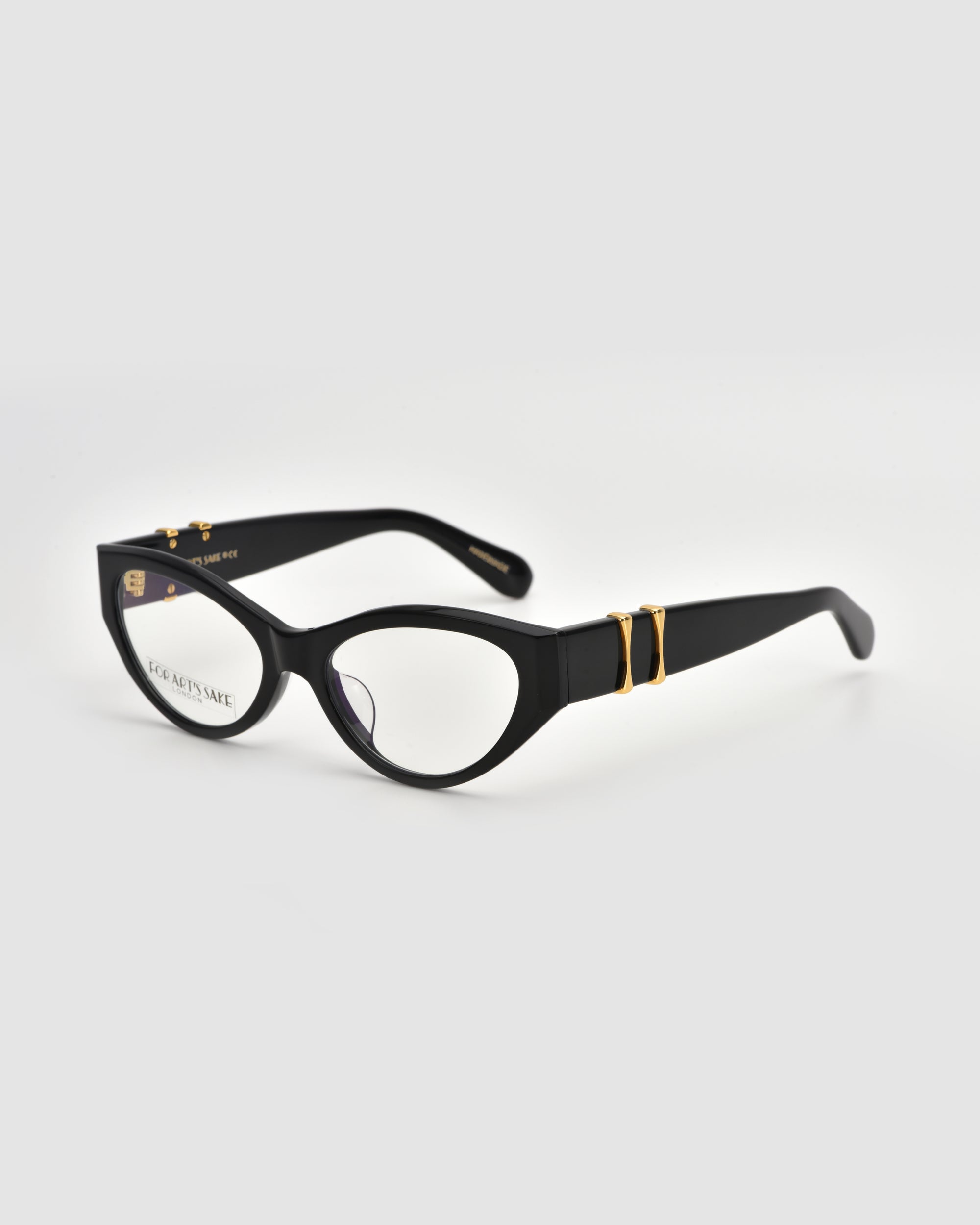 For Art's Sake® Halo(X) features black cat-eye eyeglasses with sculptural acetate frames, thick gold-accented temples, and clear lenses—chic everyday eyewear—shown on a light gray background.