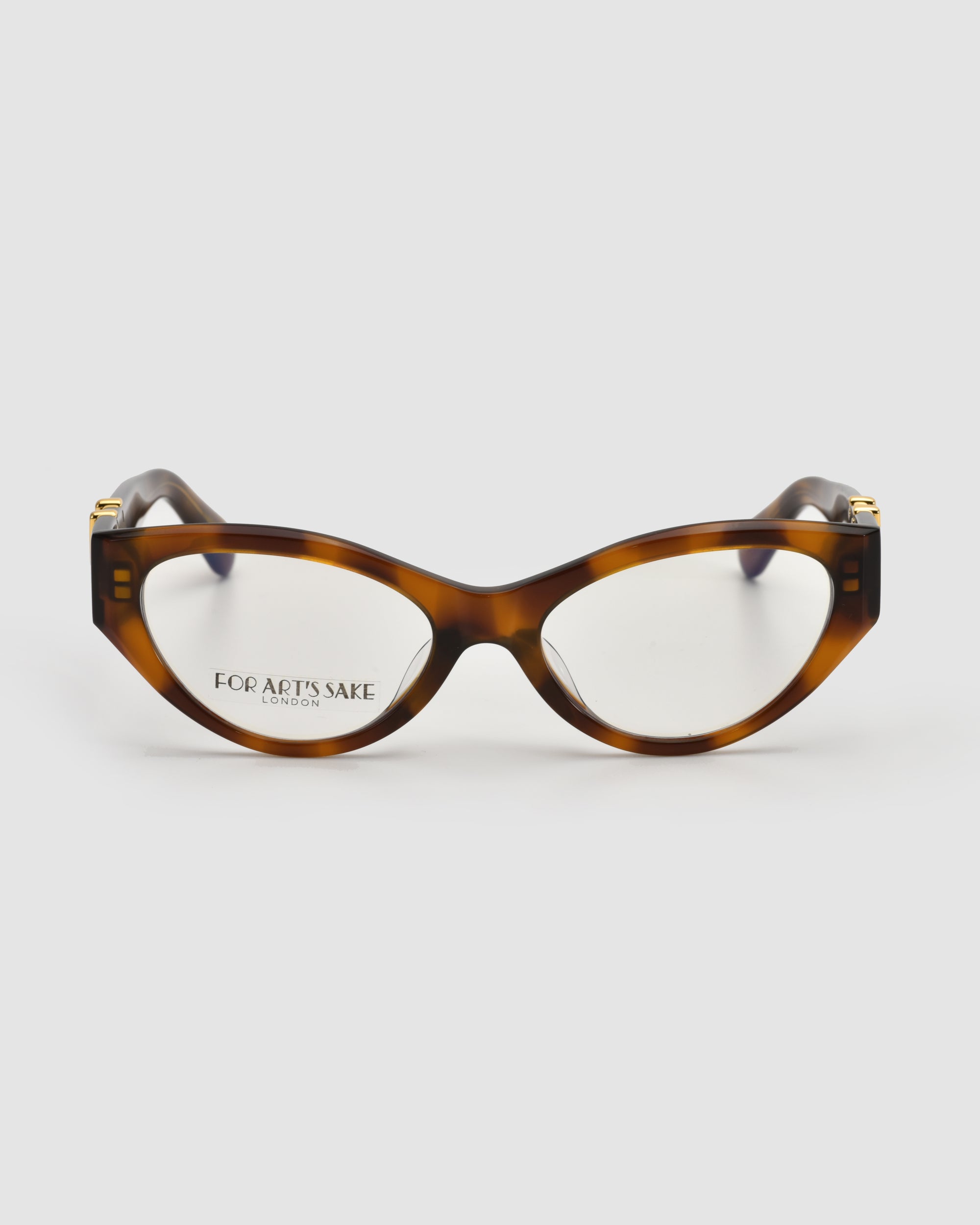 The Halo(X) cat-eye eyeglasses by For Art's Sake® feature a sculptural tortoiseshell acetate frame and clear lenses, with "FOR ART'S SAKE LONDON" printed inside. Shown on a white background, they're ideal for chic everyday style.